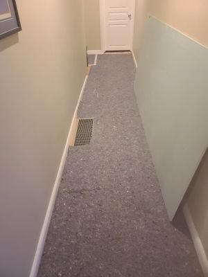 Temporary floor protection on wood floor in hallway